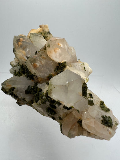 Epidote And Quartz Specimen. Stunning Quartz Cluster With Peach Inclusions Covered In Epidote.